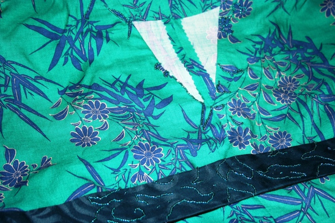 Gorgeous iridescent peacock blue/green beads give a little shine and sparkle to the neckline in random patterns, and on the belt, following the pattern of the jacquard weave.